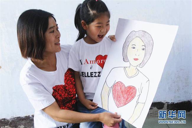 5月10日，在河北唐山市豐潤區(qū)迎賓路幼兒園開展的“媽媽，我愛你”主題活動中，陳悅寧小朋友將自己的繪畫作品送給媽媽作為節(jié)日禮物。 新華社發(fā)（朱大勇 攝）